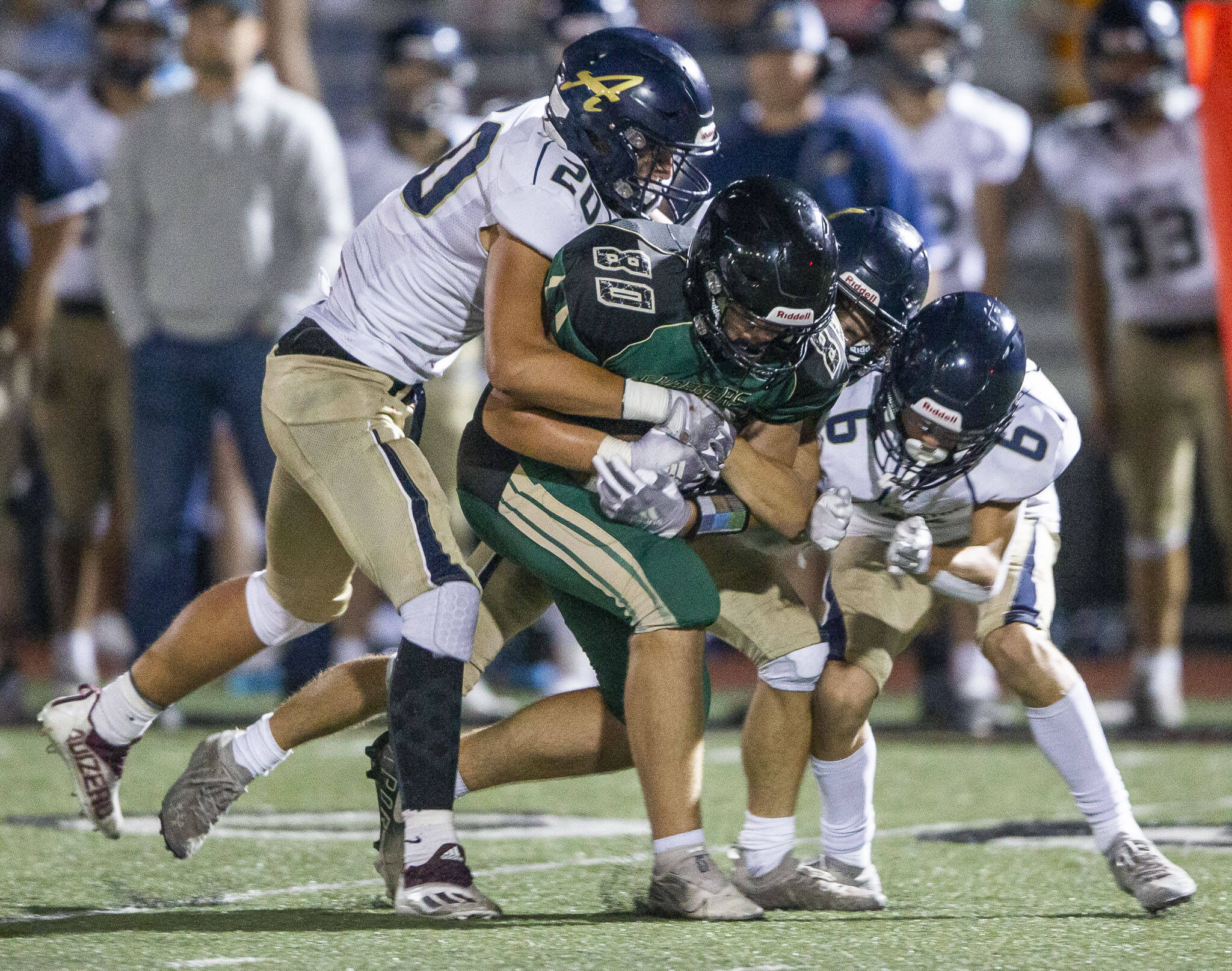 Marysville Getchell’s Wyatt Harris is tackled by multiple Arlington players during the game on Friday, Sept. 9, 2022 in Marysville, Washington. (Olivia Vanni / The Herald)