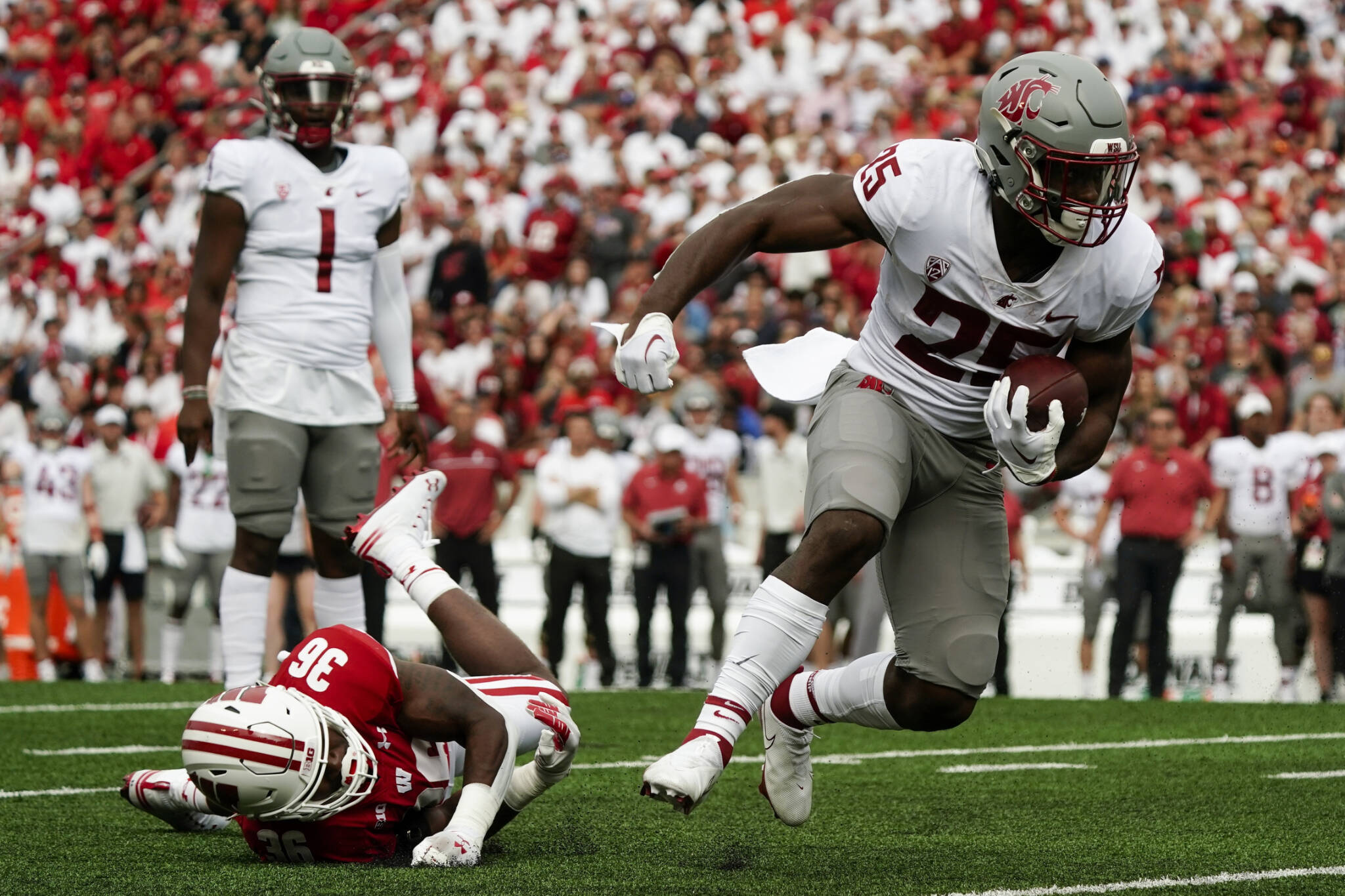 Washington State’s Nakia Watson (25) runs past Wisconsin’s Jake Chaney (36) during the first half of a game Saturday in Madison, Wis. (AP Photo/Morry Gash)