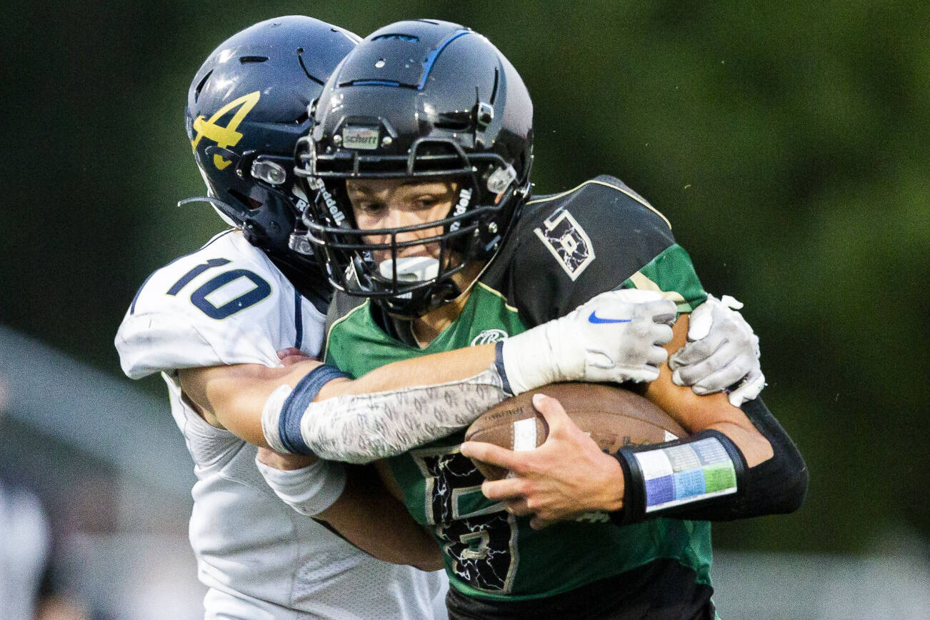 Marysville Getchell's Carter Schmidt is tackled by Arlington's Caiden Patterson during the game on Friday, Sept. 9, 2022 in Marysville, Washington. (Olivia Vanni / The Herald)