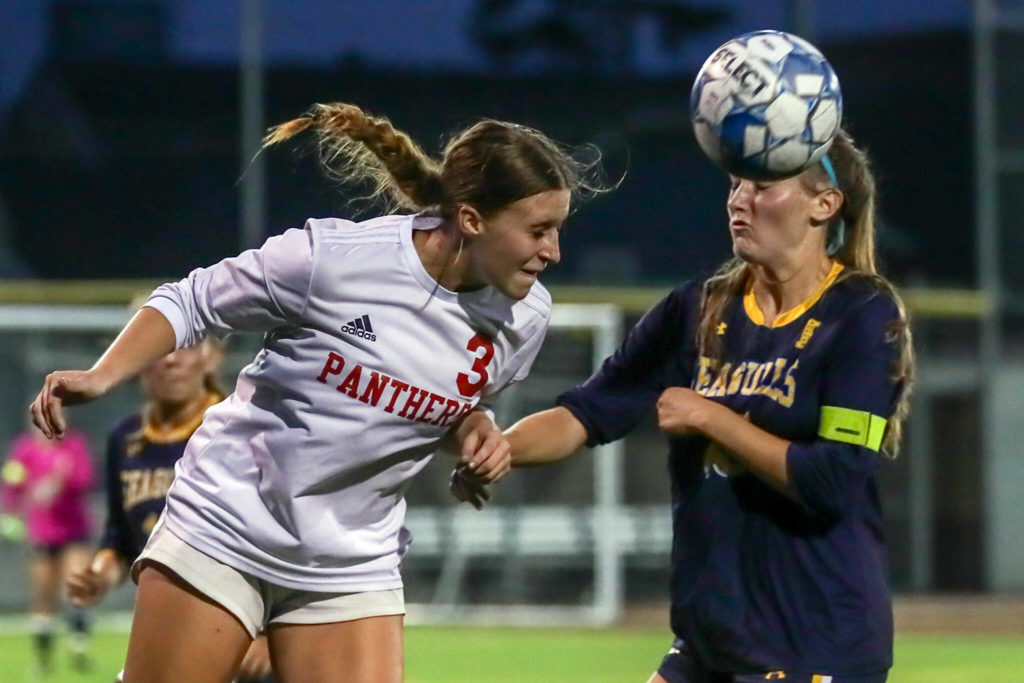 Snohomish’s Sara Rodgers, left, heads the ball with Everett’s Brittney Lemke Tuesday evening in Everett, Washington on September 13, 2022. The Panthers defeated the Eagles 3-1. (Kevin Clark / The Herald)
