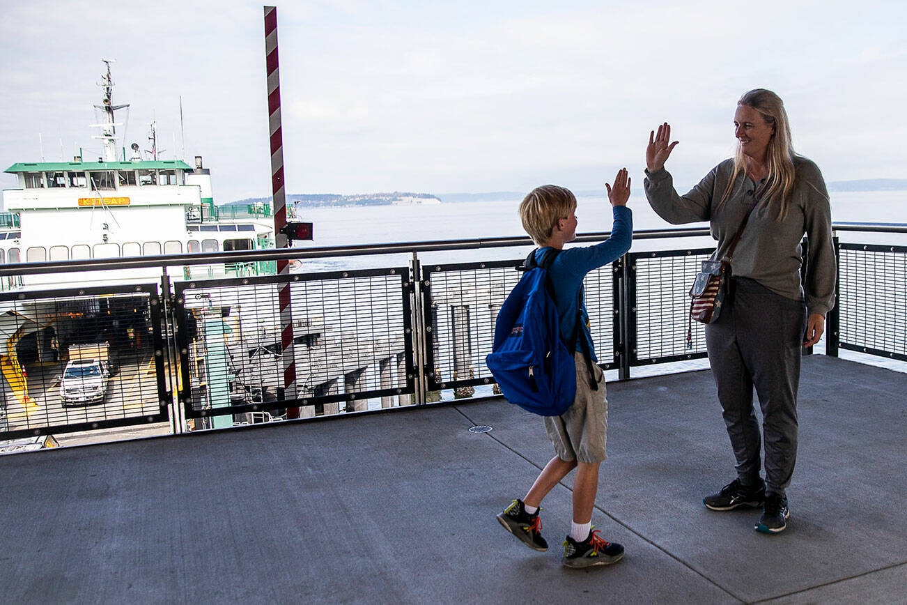 Genghin Carroll, 8, walks up and high fives his mom Andria Carroll after riding the ferry over to meet her for a dental appointment on Thursday, Sept. 29, 2022 in Mukilteo, Washington. (Olivia Vanni / The Herald)