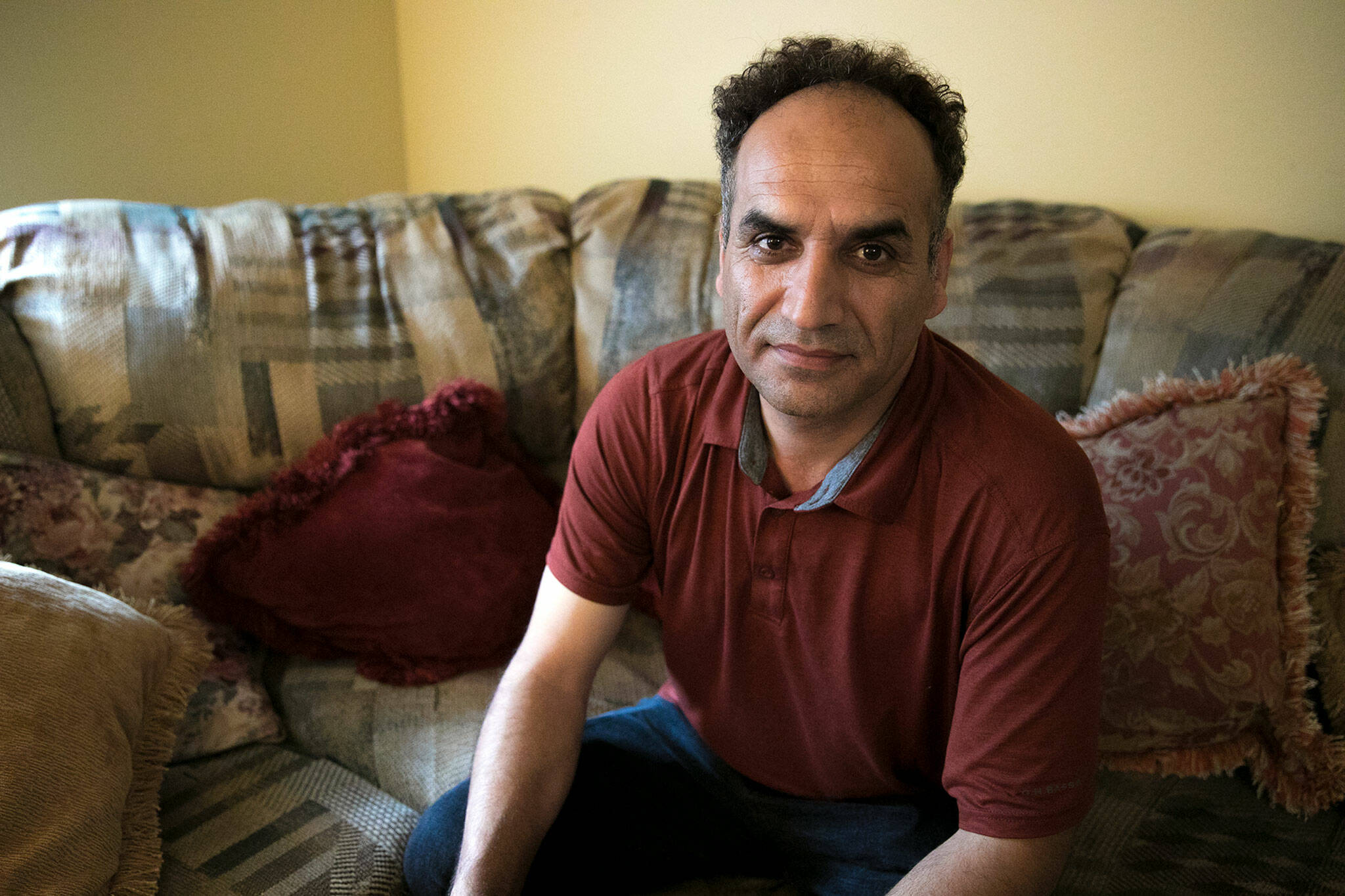 Ziaurahman Ahadi, an Afghan immigrant and former field medic for American forces during the U.S.’s occupation of Afghanistan, sits inside his family’s apartment on Sep. 3, in Lynnwood. (Ryan Berry / The Herald)