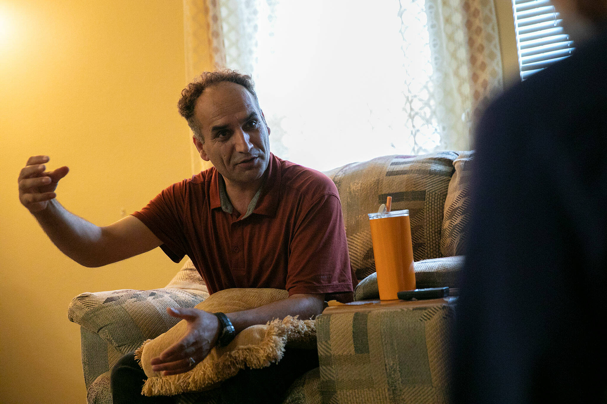 Ziaurahman Ahadi, an Afghan immigrant and former field medic for American forces during the U.S.’s occupation of Afghanistan, speaks via a translator inside his family’s apartment on Sep. 3, in Lynnwood. (Ryan Berry / The Herald)