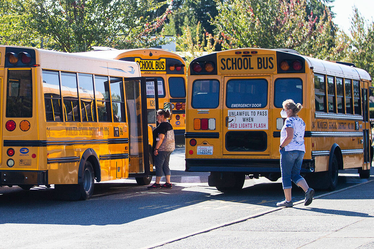 Challenger Elementary School staff chats with bus drivers before school lets out on Monday, Sept. 19, 2022 in Everett, Washington. (Olivia Vanni / The Herald)
