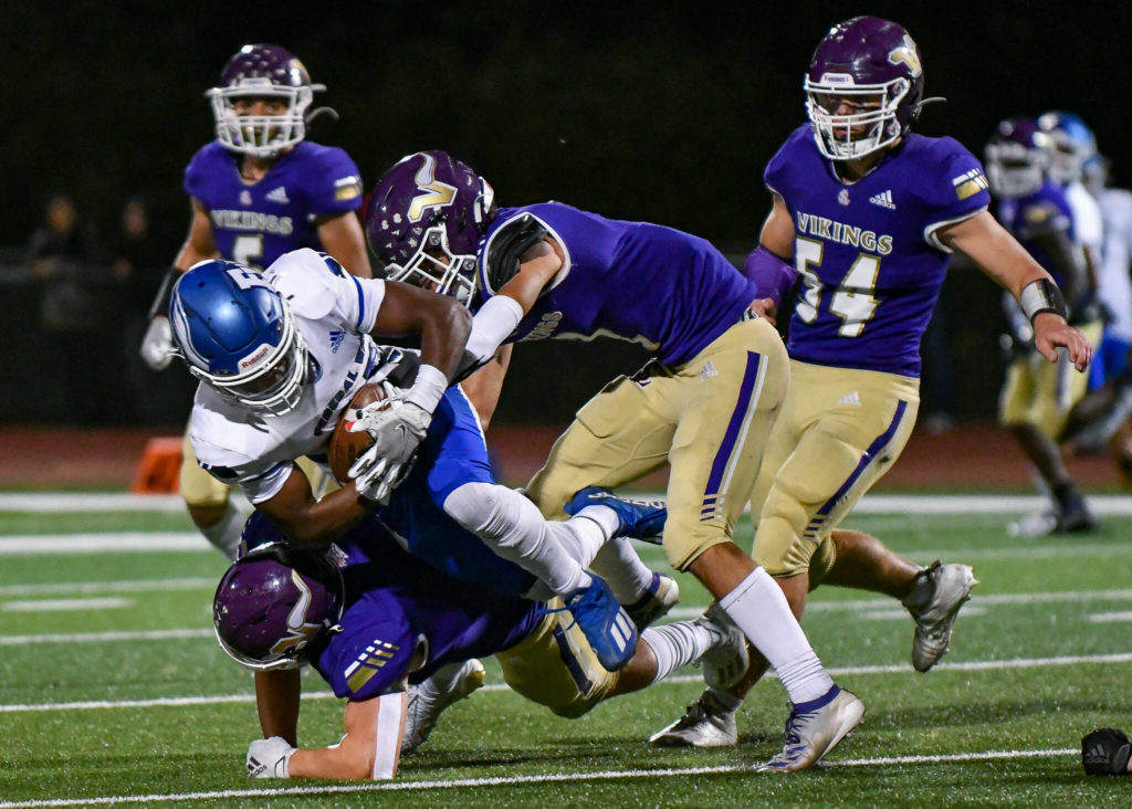 Lake Stevens’ Joe McGinnis (bottom) and Steven Lee (top) work together to bring down a Federal Way runner as Lake Stevens’ Gabe Kylany (6) and Mason Turner (54) look on during a game on Friday, Sept. 16, 2022, at Lake Stevens High School. (John Gardner / Pro Action Image)
