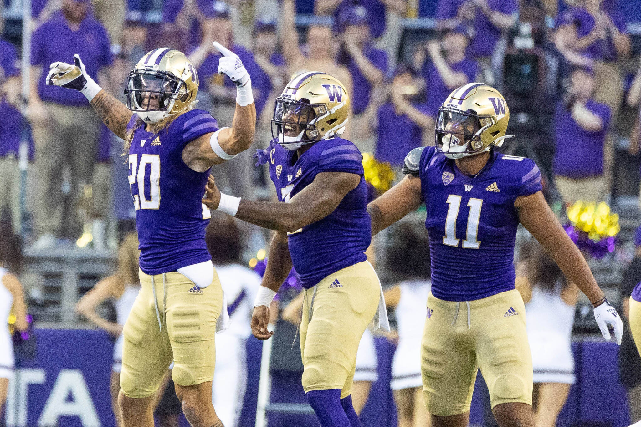 Washington’s Asa Turner (left) celebrates his interception with teammates during the first half of a game against Kent State on Sept. 3 in Seattle. (Dean Rutz/The Seattle Times via AP)