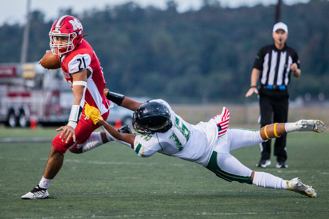 Marysville Getchell's Dylan Padilla dives to try and tackle Marysville Pilchuck’s Kenai Sinaphet during the annual Berry Bowl game on Friday, Sept. 16, 2022 in Marysville, Washington. (Olivia Vanni / The Herald)