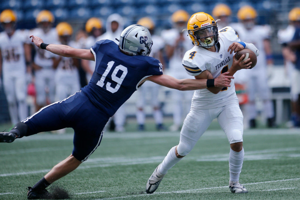 Ferndale’s Bishop Ootsey evades a sack before scrambling for a solid gain against Glacier Peak on Saturday, Sep. 17, 2022, at Lumen Field in Seattle, Washington. (Ryan Berry / The Herald)
