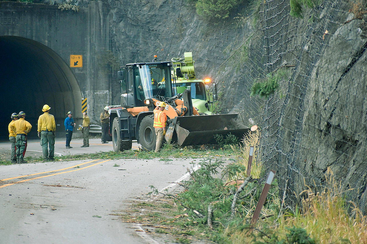 Crews work to clear debris from U.S. 2 on Saturday, after the Bolt Creek fire destabilized the steep terrain. (Lauren Bonney, PIO NW team 8)