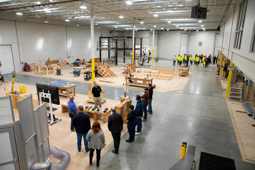 A pair of group tours make their way around the Northwest Carpenters Institute’s new center during the building’s grand opening on Thursday, in Burlington. (Ryan Berry / The Herald)
