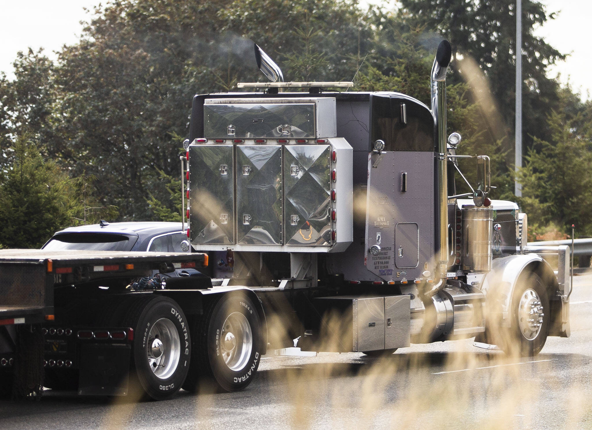 A semi truck blows smoke out of its exhaust pipes Friday while driving southbound on I-5 in Everett. (Olivia Vanni / The Herald)