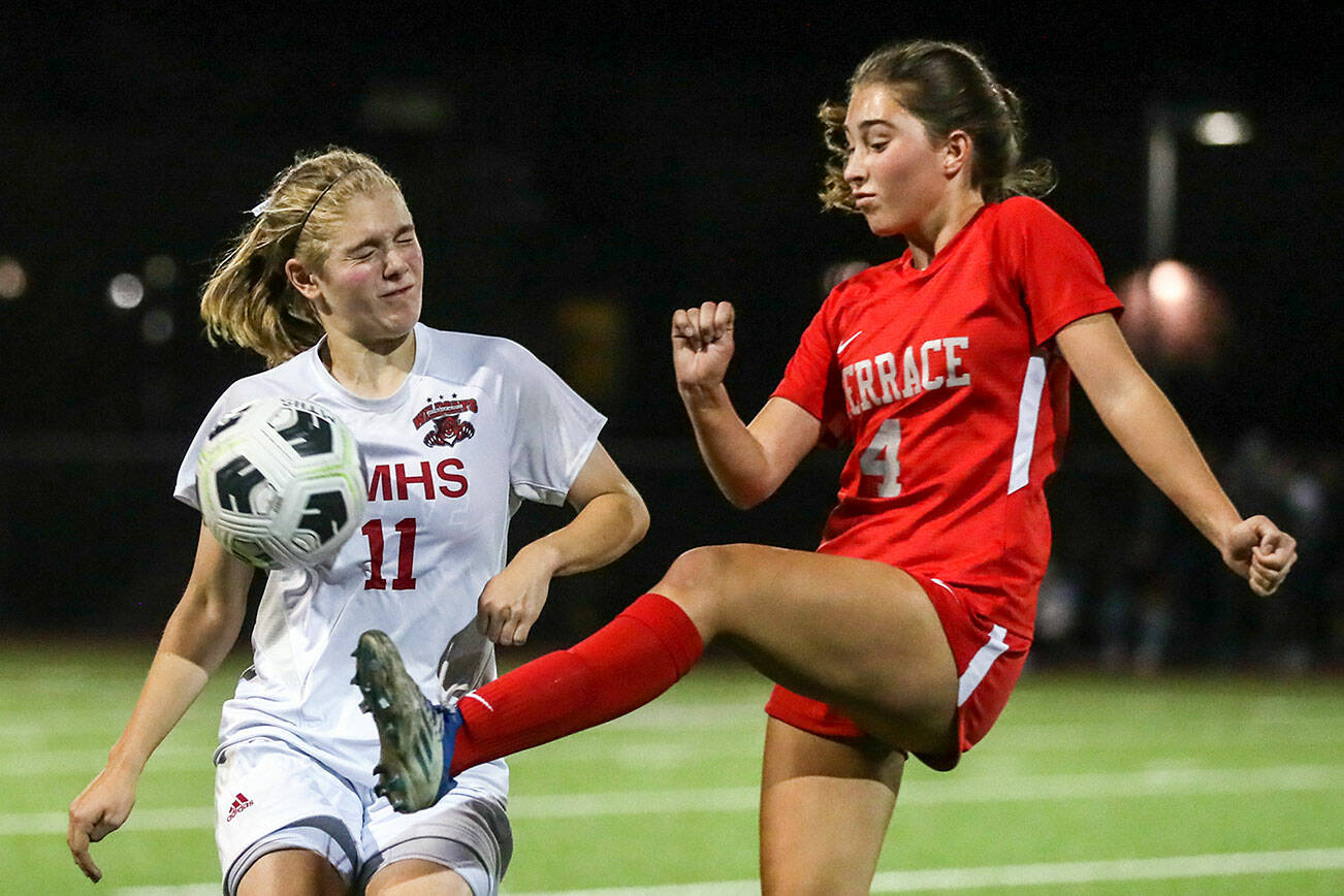 Archbishop Murphy's Georgia Franck, left, Mountlake Terrace's Claire August vie for control of a loose ball Thursday night at Lynnwood High School in Lynnwood, Washington on September 22, 2022. The Hawks and Wildcats finished the match with 1-1 tie. (Kevin Clark / The Herald)