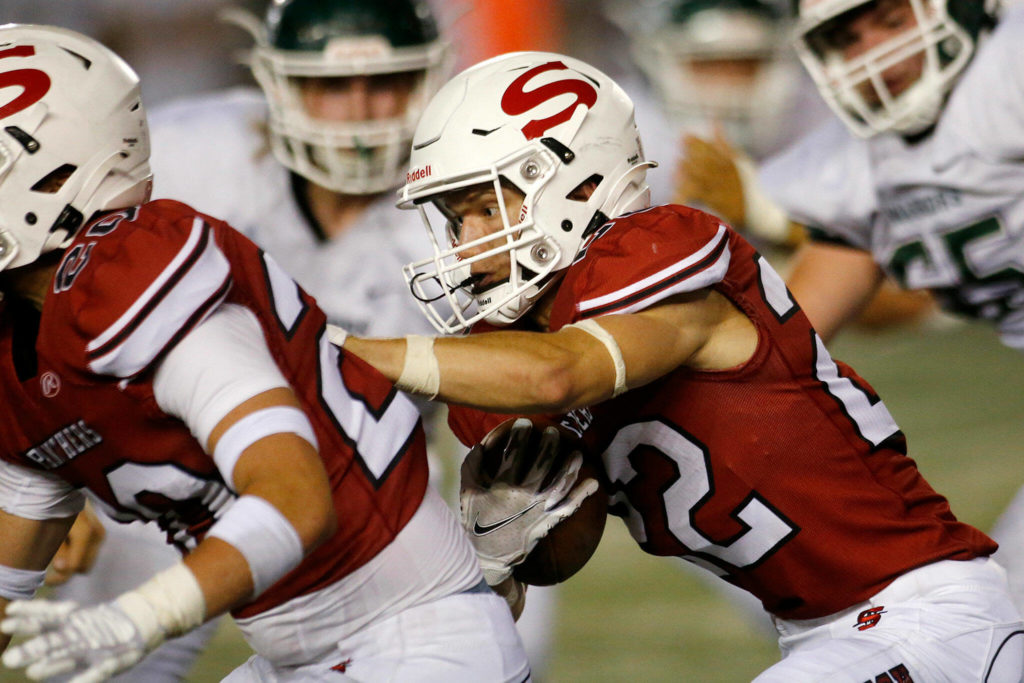 Snohomish’s Kyle Larson stays behind a blocker on a run against Edmonds-Woodway on Friday, Sep. 23, 2022, at Snohomish High School in Snohomish, Washington. (Ryan Berry / The Herald)
