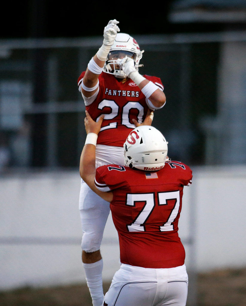 Snohomish’s Deshaun Snyder lifts Mason Orgill after Orgill’s first touchdown of the day against Edmonds-Woodway on Friday, Sep. 23, 2022, at Snohomish High School in Snohomish, Washington. (Ryan Berry / The Herald)
