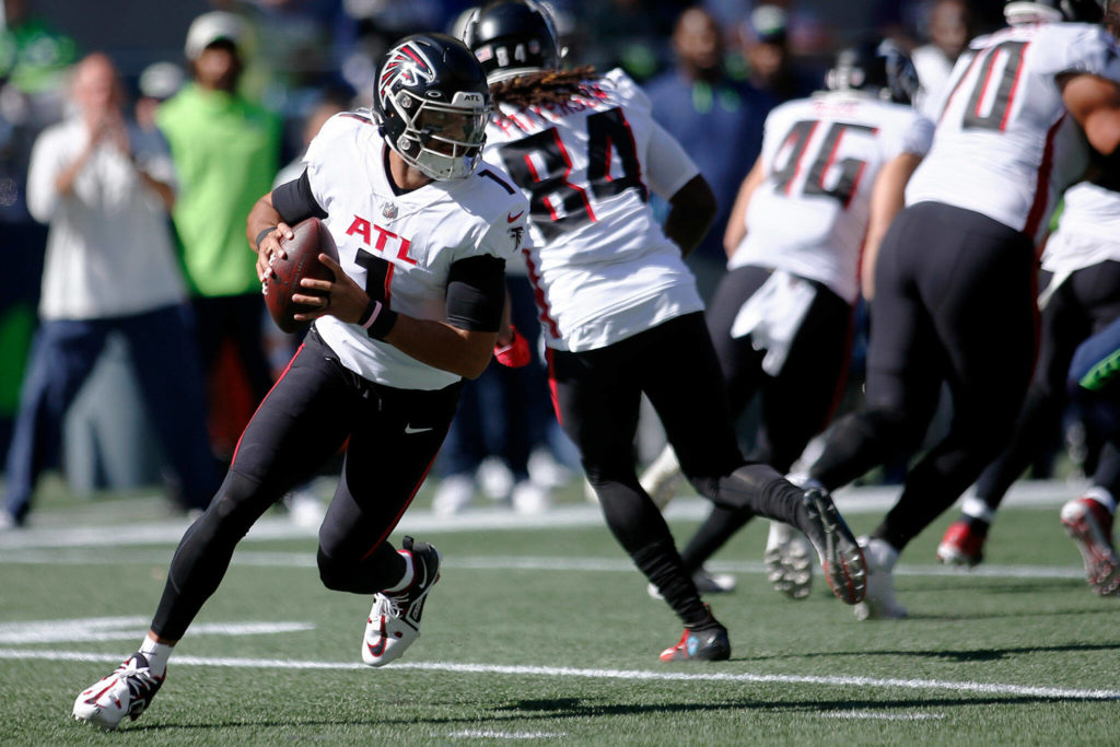 The Atlanta Falcons’ Marcus Mariota rolls out of the pocket against the Seattle Seahawks on Sunday, Sep. 25, 2022, at Lumen Field in Seattle, Washington. (Ryan Berry / The Herald)
