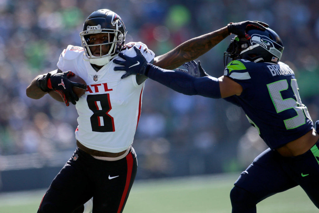 The Atlanta Falcons’ Kyle Pitts throws a stiff arm while running with the ball against the Seattle Seahawks on Sunday, Sep. 25, 2022, at Lumen Field in Seattle, Washington. (Ryan Berry / The Herald)
