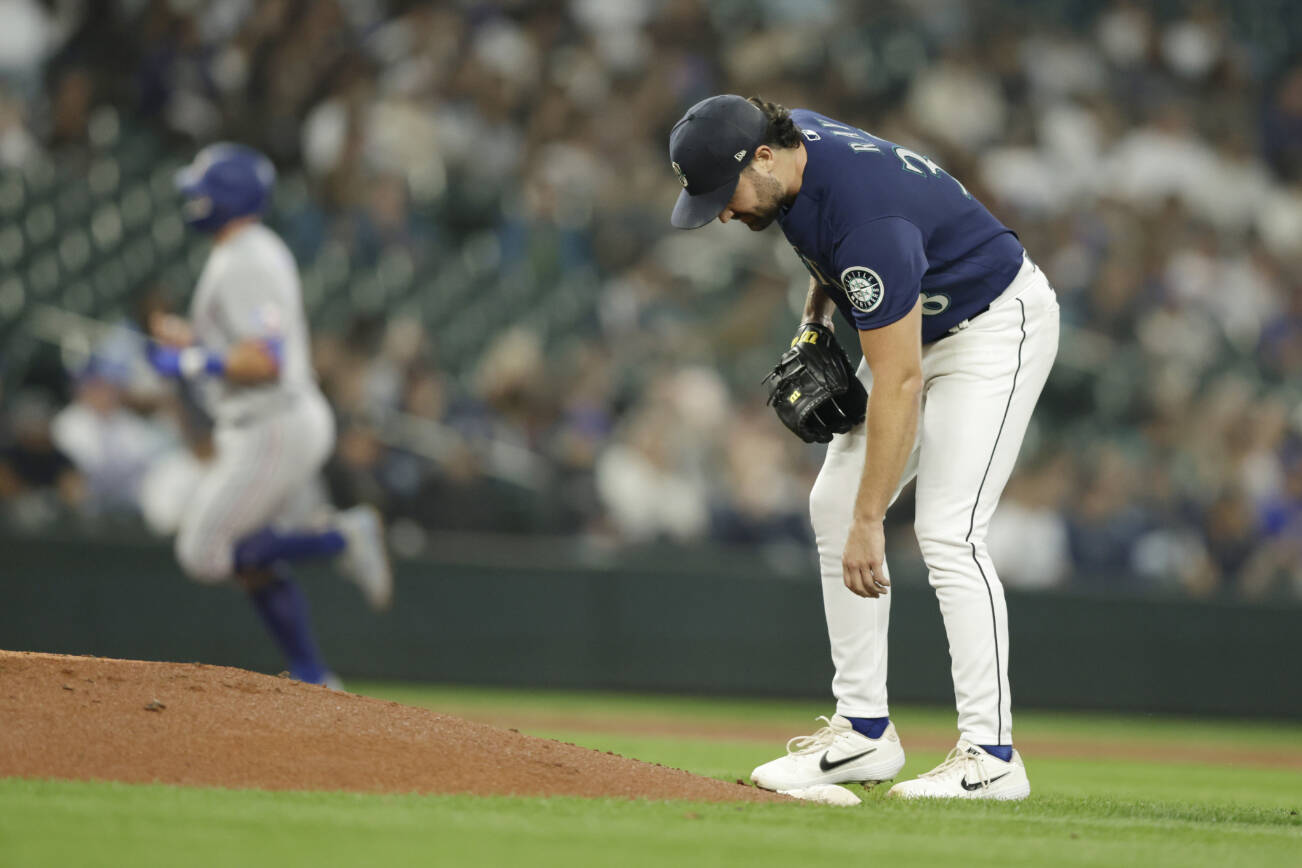 Texas Rangers' Josh Jung rounds the bases behind on his solo home run as Seattle Mariners starting pitcher Robbie Ray bends down to pick up the rosin bag during the second inning of a baseball game, Tuesday, Sept. 27, 2022, in Seattle. (AP Photo/John Froschauer)
