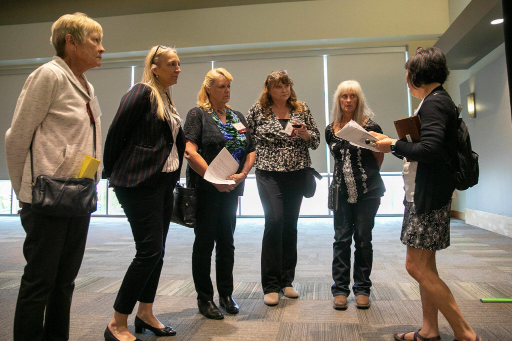 Members of the 1982 Arlington girls basketball team receive a brief rundown of the night’s events before the 2022 Snohomish County Sports Hall of Fame banquet Wednesday, Sep. 28, 2022, at the Edward D. Hansen Conference Center in Everett, Washington. (Ryan Berry / The Herald)
