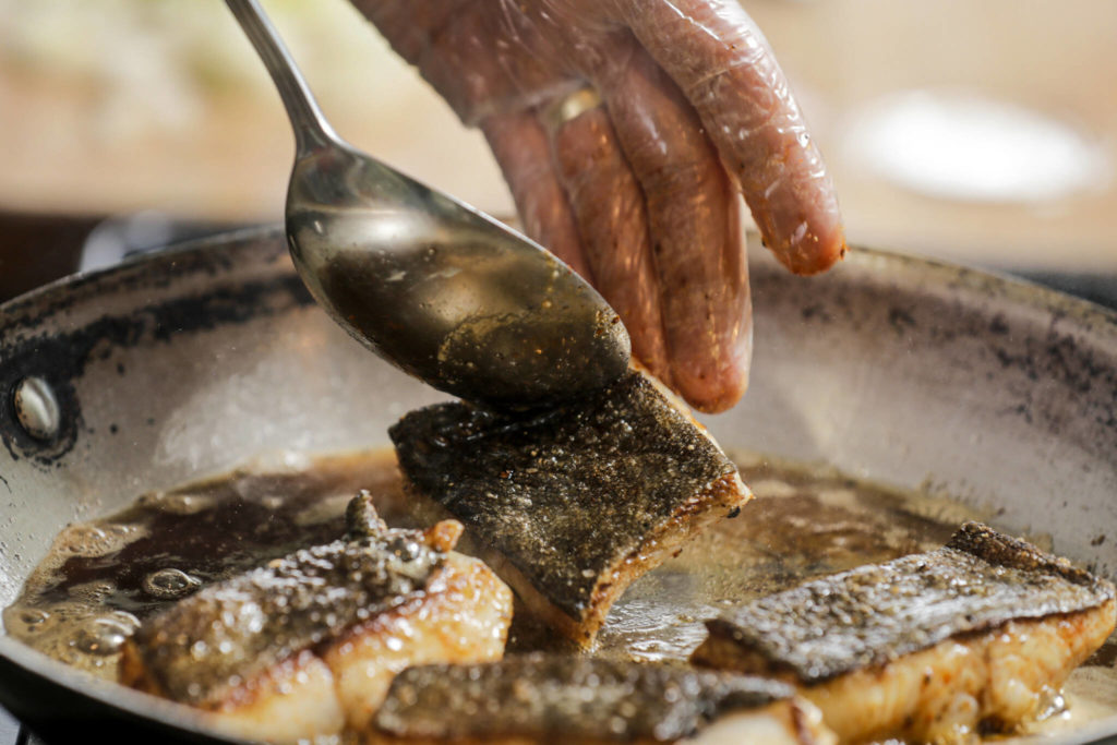 Castiglia pan-fries black cod, also known as sablefish. He sourced the fish from Laurie and Gary Olsen’s fish selling/delivery business. (Kevin Clark / The Herald)
