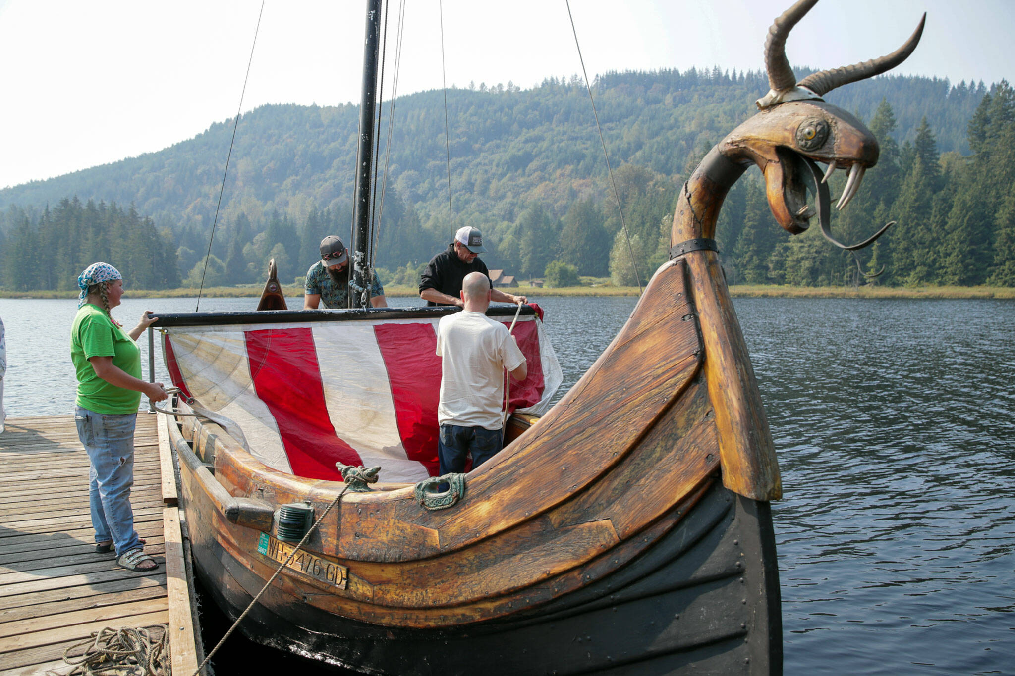 Sons of Norway members raise the sail on Osa at Lake Riley at Normanna Park. (Kevin Clark / The Herald)