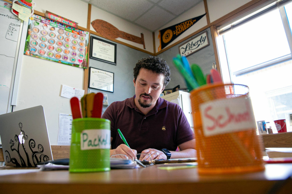 Zachary Pfrimmer grades assignments while his students work with another teacher in his fourth-grade classroom at Cedarhome Elementary on Sep. 21, in Stanwood. (Ryan Berry / The Herald)
