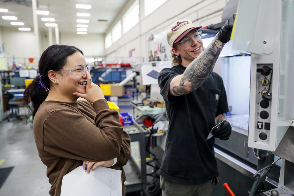 Analisa Paterno of Marysville-Getchell, left, shares a laugh with Nathan Harms on Sept. 23, at Pathfinder Manufacturing in Everett. (Kevin Clark / The Herald)
