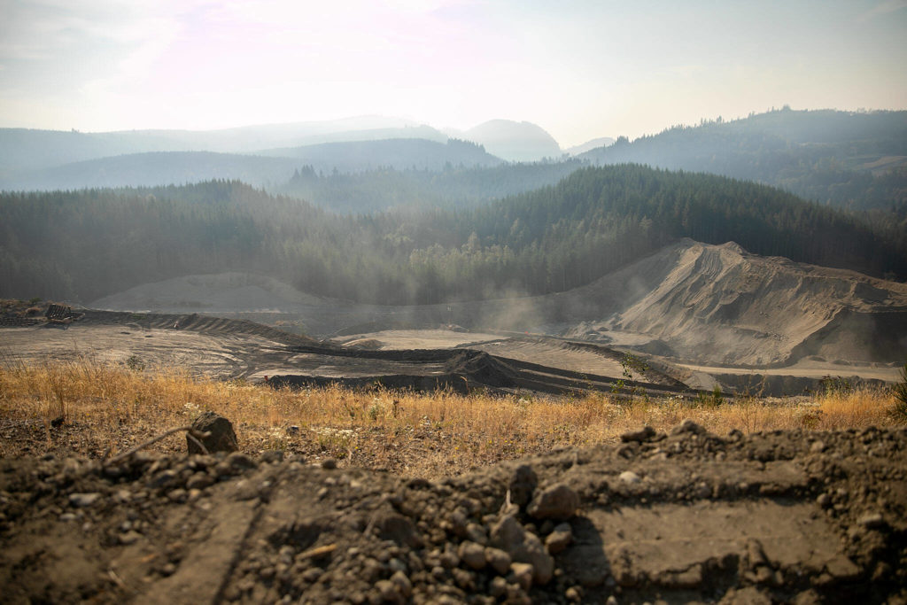 Dust rises up and wildfire smoke descends upon a sand and gravel mine at Cadman, Inc.’s Granite Falls location on Monday, in Granite Falls. (Ryan Berry / The Herald)
