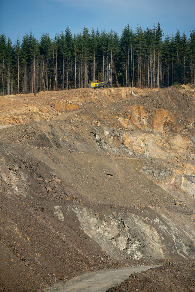 A drill machine makes holes along a ridge in preparation for blasting during an expansion of the quarry at the Cadman, Inc. sand and gravel mine on Monday, in Granite Falls. (Ryan Berry / The Herald)
