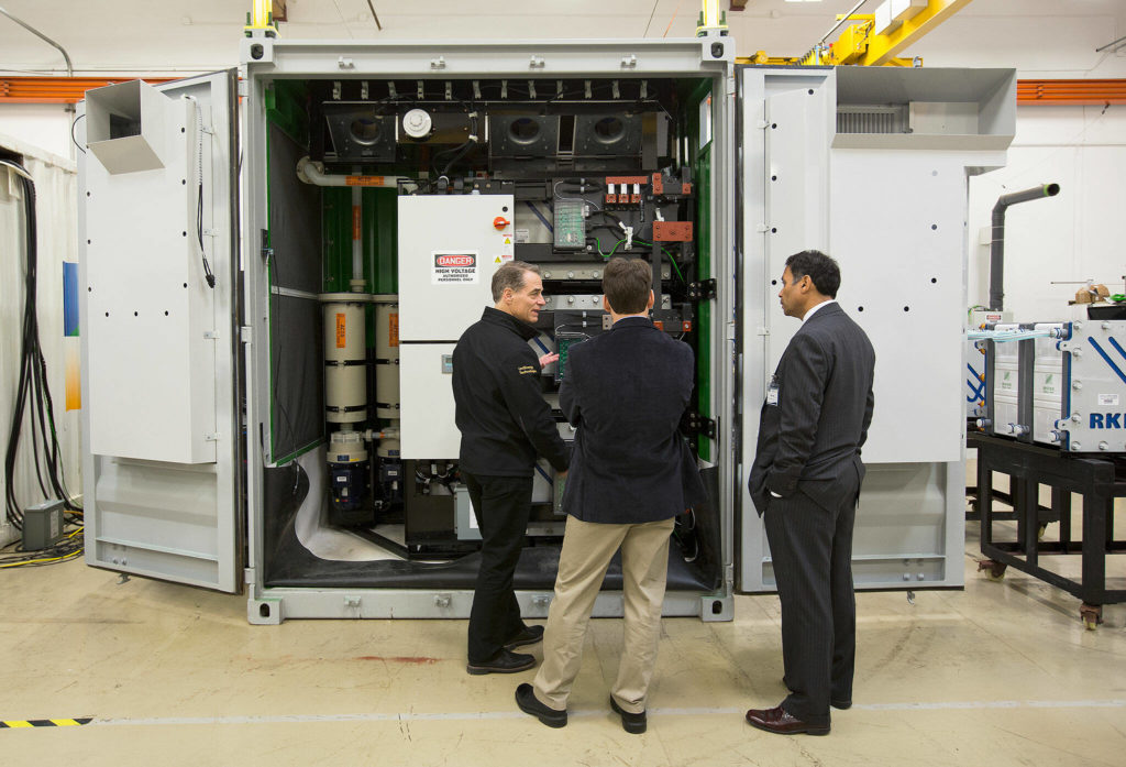 Brad Kell, UniEnergy Technologies Vice President of Deployment and Field Service, explains how a flow-battery system works to two guests before a dedication ceremony for Snohomish Public Utility District’s second energy storage system on March 28, 2017 in Mukilteo. The system is largest containerized vanadium flow battery in the world by capacity. The project is part of the PUD’s efforts to shape the energy storage market. This system was paid for in part with money from the Washington State Clean Energy Fund. (Andy Bronson / The Herald file)
