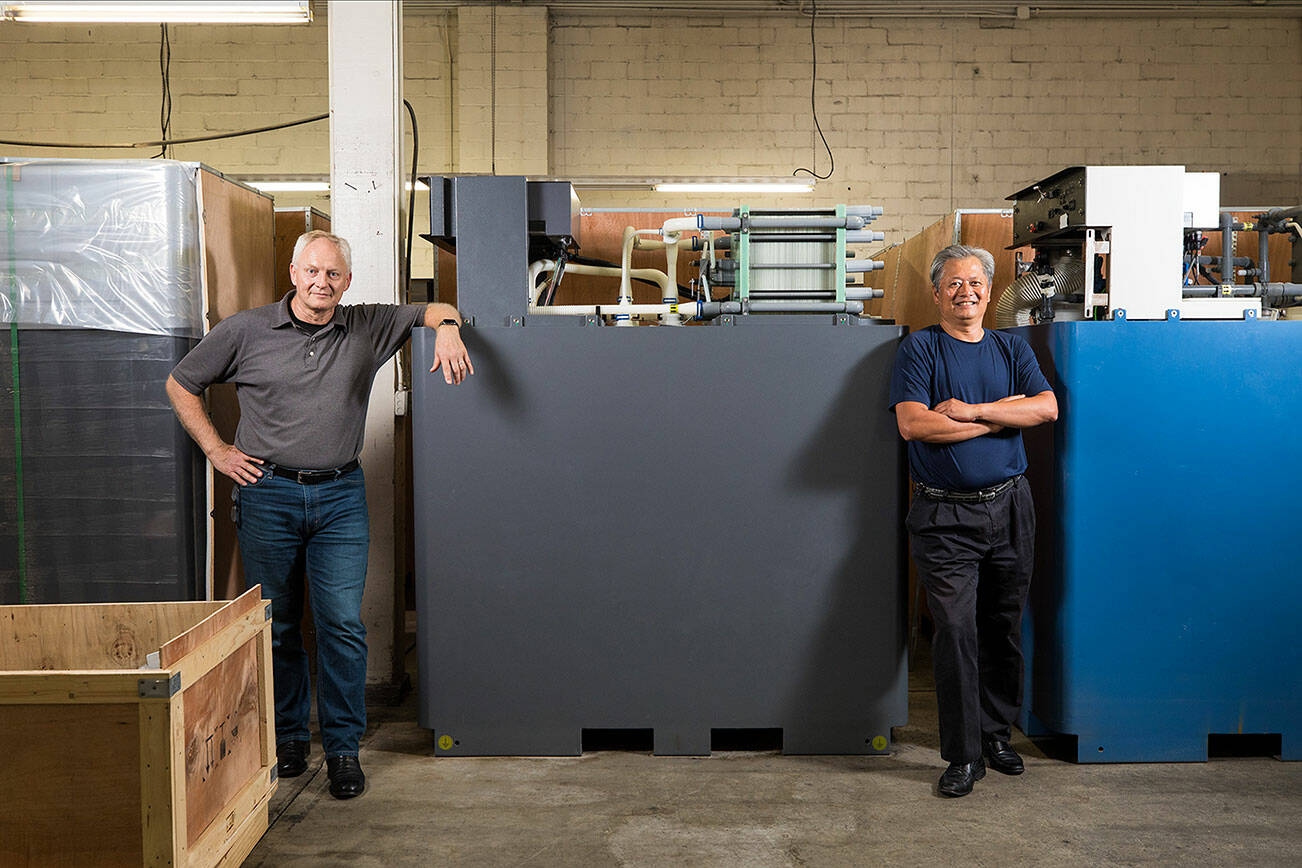 Rick Winter (left) and Gary Yang, the founders of the former UniEnergy Technologies, stand with one their latest batteries, the Reflex, August 10, 2022. (Dan DeLong/InvestigateWest)