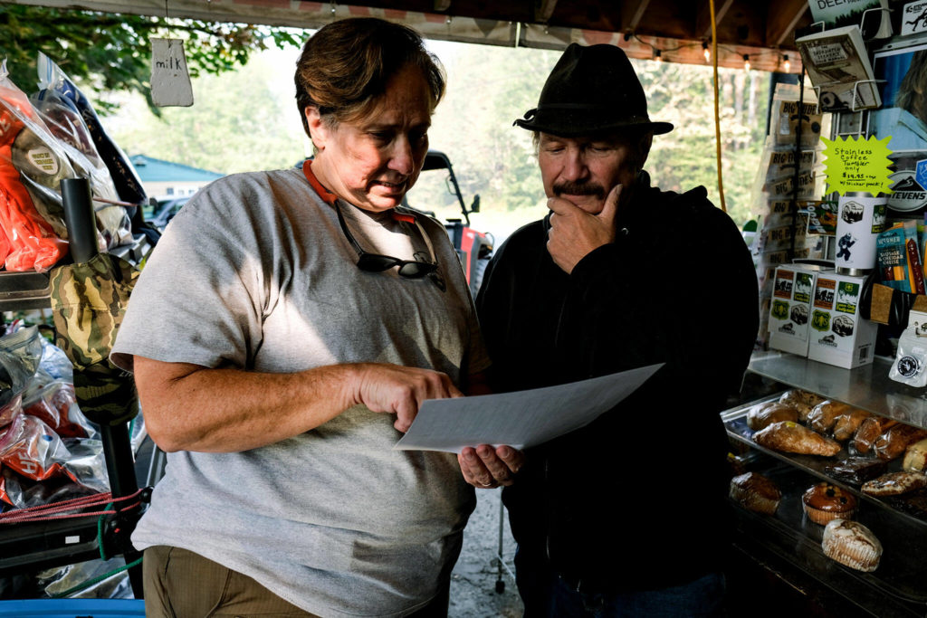 Lynda Lancaster, a PIO on the Bolt Creek Fire, goes over a daily update with Espresso Chalet owner Mark Klein in Gold Bar on Sept. 27. (Taylor Goebel / The Herald)
