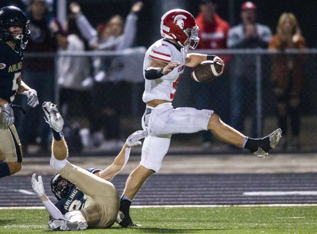 Stanwood’s Ryder Bumgarner runs through a tackle by Arlington’s Aiden Meis for a touchdown during the Stilly Cup rivalry game on Friday, Sept. 30, 2022 in Arlington, Washington. (Olivia Vanni / The Herald)
