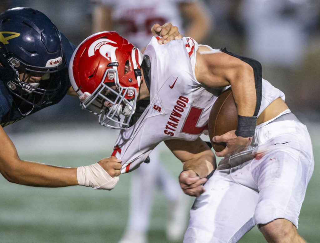 Stanwood’s Ryan Bumgarner’s jersey is pulled by an Arlington player during the Stilly Cup on Friday, Sept. 30, 2022 in Arlington, Washington. (Olivia Vanni / The Herald)
