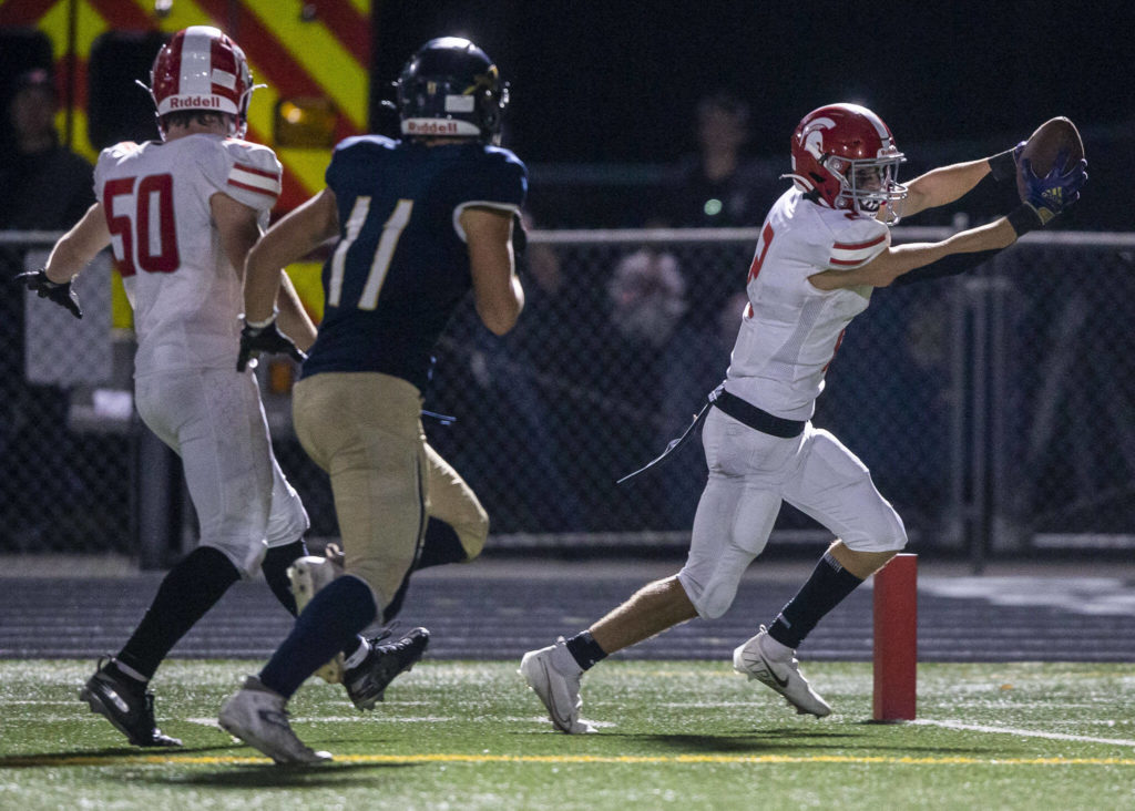 Stanwood’s Canyon Bumgarner reaches the ball in to the end zone looking for a touchdown during the Stilly Cup against Arlington on Friday, Sept. 30, 2022 in Arlington, Washington. (Olivia Vanni / The Herald)
