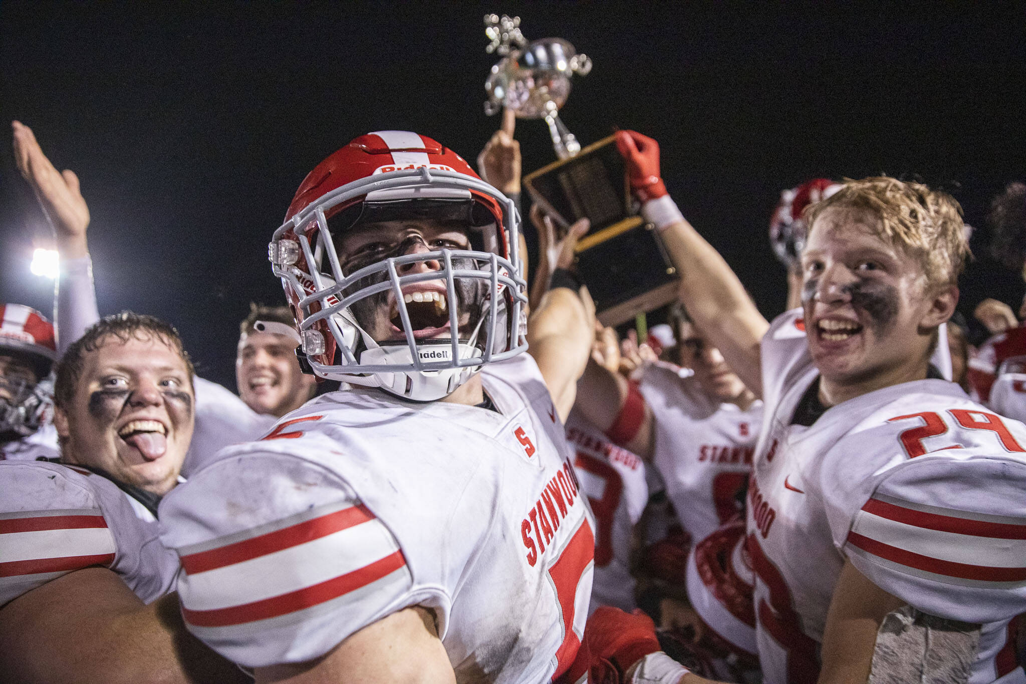 Ryder Bumgarner and his Stanwood teammates celebrate after beating rival Arlington 37-6 Friday night to win the Spartans’ first Stilly Cup in 13 years. (Olivia Vanni / The Herald)