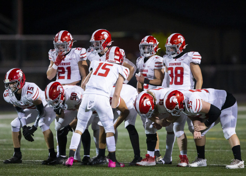 Stanwood players lineup to hear the play call from their quarterback Michael Mascotti during the Stilly Cup against Arlington on Friday, Sept. 30, 2022 in Arlington, Washington. (Olivia Vanni / The Herald)
