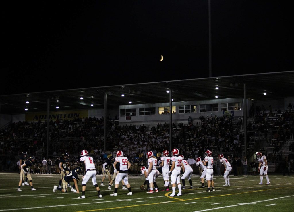 A crescent moon is visible above the bleachers during the Stilly Cup on Friday, Sept. 30, 2022 in Arlington, Washington. (Olivia Vanni / The Herald)
