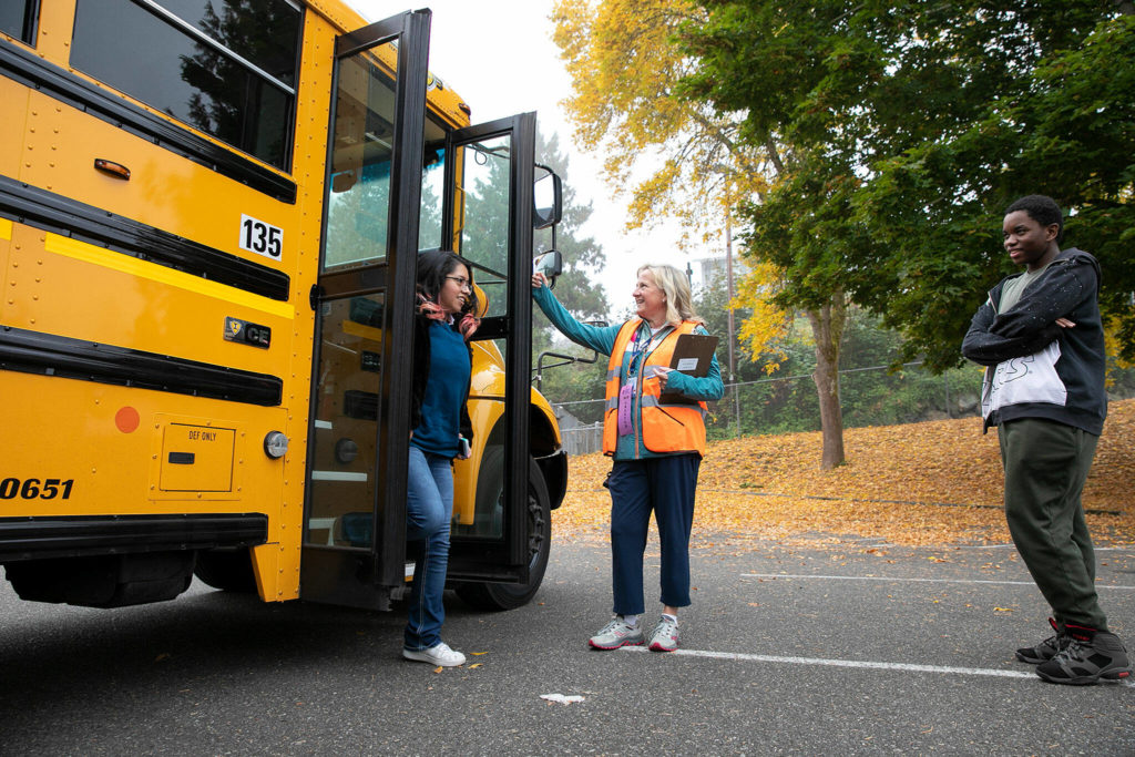 Everett Public Schools’ Randi Seaberg guides students from Henry M. Jackson High School as they get off the bus during an EPS emergency drill on Thursday, at Everett Memorial Stadium in Everett. (Ryan Berry / The Herald)
