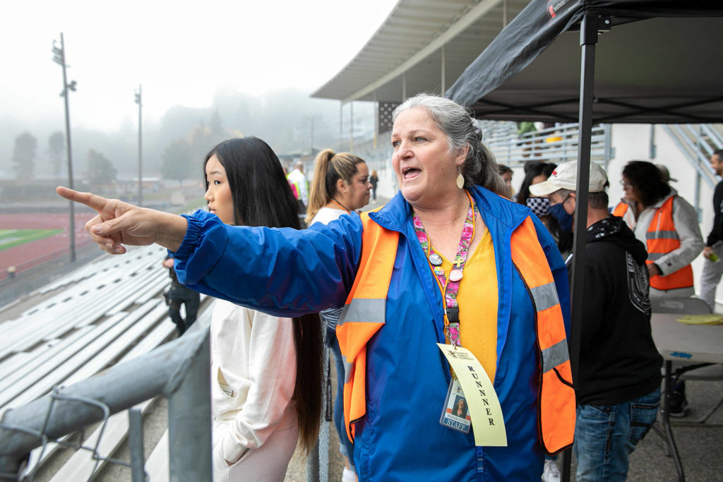Michelle Ulke shows students where to go after being united with their pretend guardians during an Everett Public Schools emergency drill on Thursday, at Everett Memorial Stadium in Everett. (Ryan Berry / The Herald)
