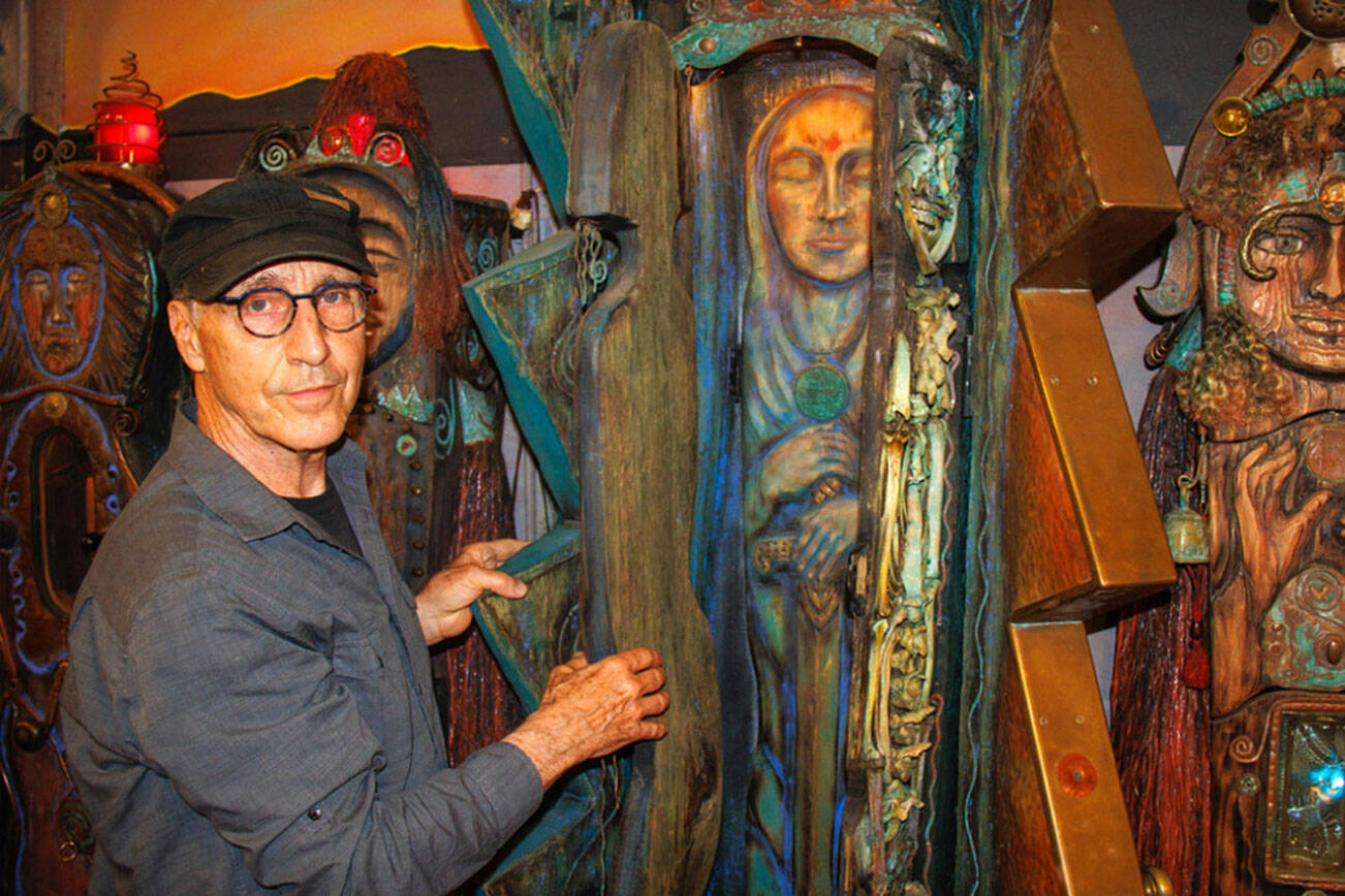 Jerry Wennstrom with “Lightning,” a multi-layered sculpture. Wennstrom’s second body of artistic work consists of several tall, wooden sculptures resembling women that are meant to represent complex themes of birth and death, good and evil, femininity and masculinity. (David Welton)