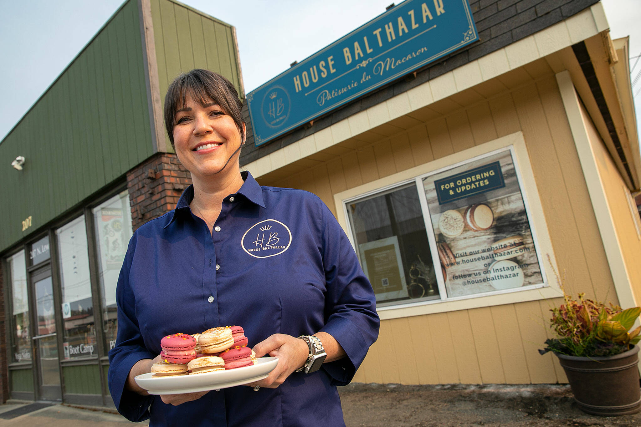 Lisa Laidlaw stands outside of the tiny storefront of House Balthazar, her new macaron patisserie, on Oct. 17, in Monroe. (Ryan Berry / The Herald)
