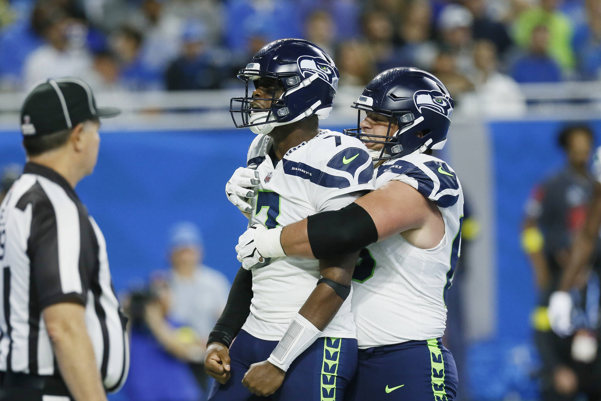 Seattle Seahawks quarterback Geno Smith is hugged by center Austin Blythe, right, after Smith rushed for an 8-yard touchdown during the first half of Sunday’s game against the Detroit Lions. (AP Photo/Duane Burleson)