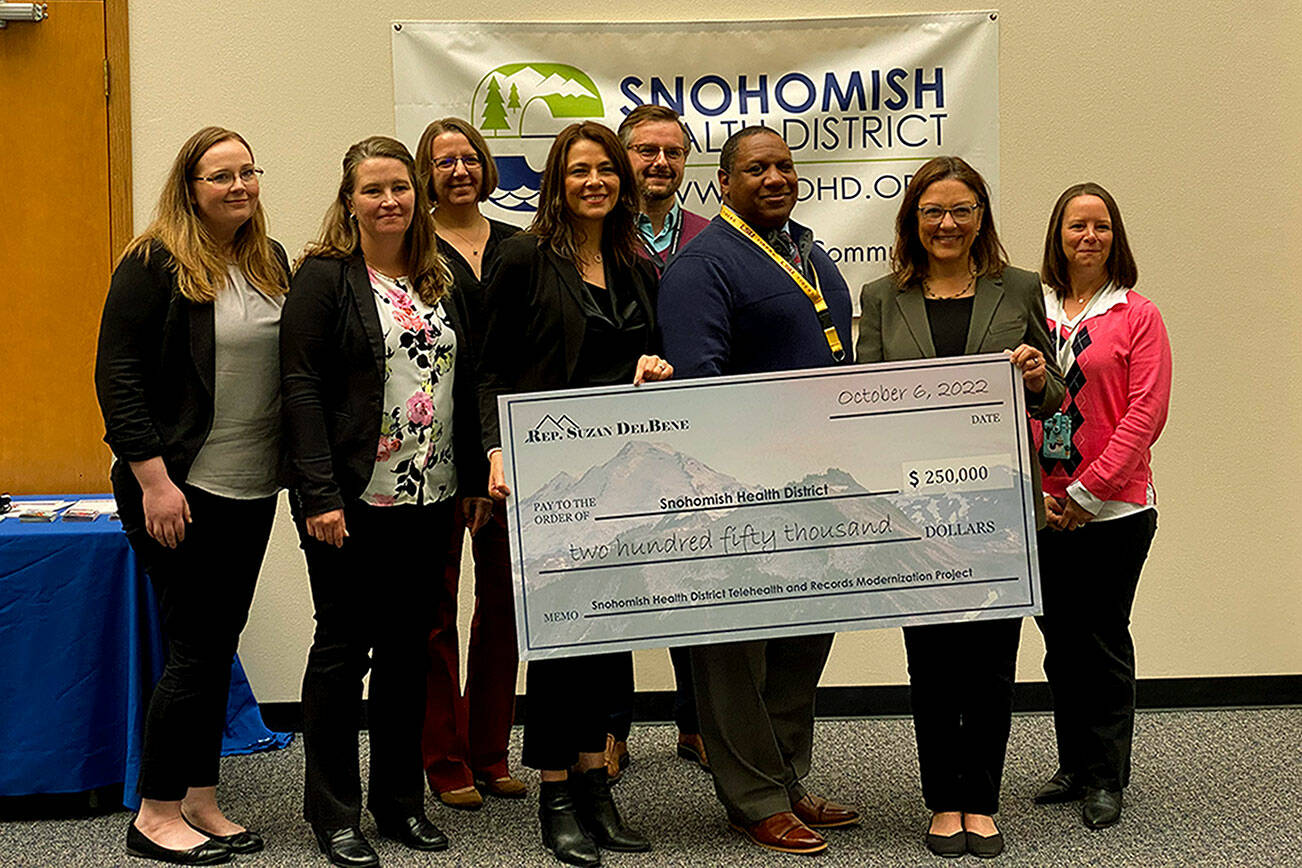 Snohomish Health District officials gathered to accept a $250,000 check from U.S. Rep. Suzan DelBene on Thursday. (Kayla Dunn / The Herald)