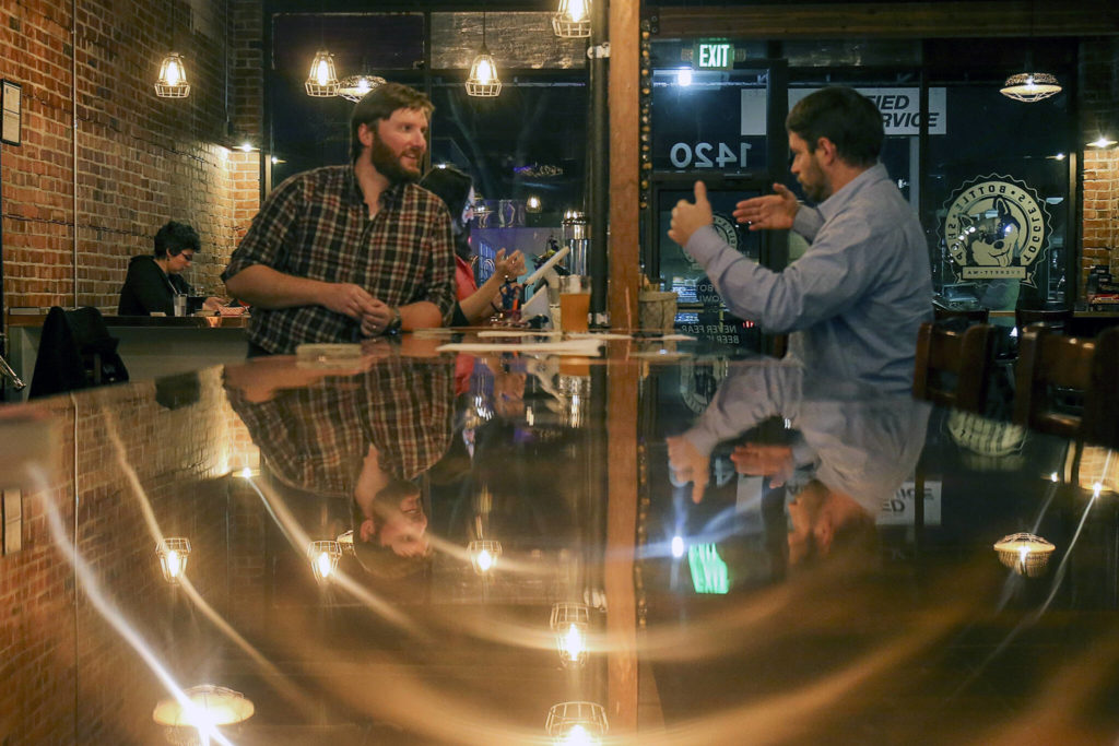 Colin Lothrop, left, talks with Sean Curran at Toggle’s Bootleshop in Everett on Nov. 8, 2017. (Kevin Clark / The Herald) 
