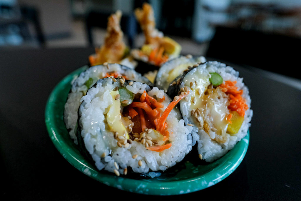 Bapmukja, a new Korean street food eatery in Lynnwood, rolls their shrimp tempura kimbap with a fluffy egg sheet, asparagus, carrots and pickled radish, then finishes it with a sweet honey sauce and toasted sesame seeds. (Taylor Goebel / The Herald)
