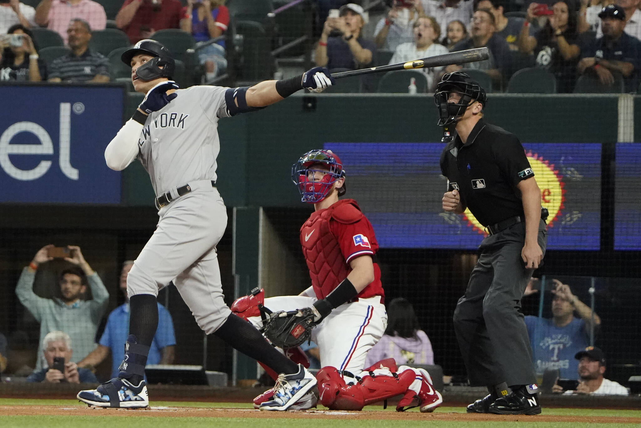 The Yankees’ Aaron Judge (left) hits a solo home, his 62nd of the season, in front of Rangers catcher Sam Huff and home plate umpire Chris Segal during the first inning of the second baseball game of a doubleheader on Tuesday in Arlington, Texas. (AP Photo/LM Otero)