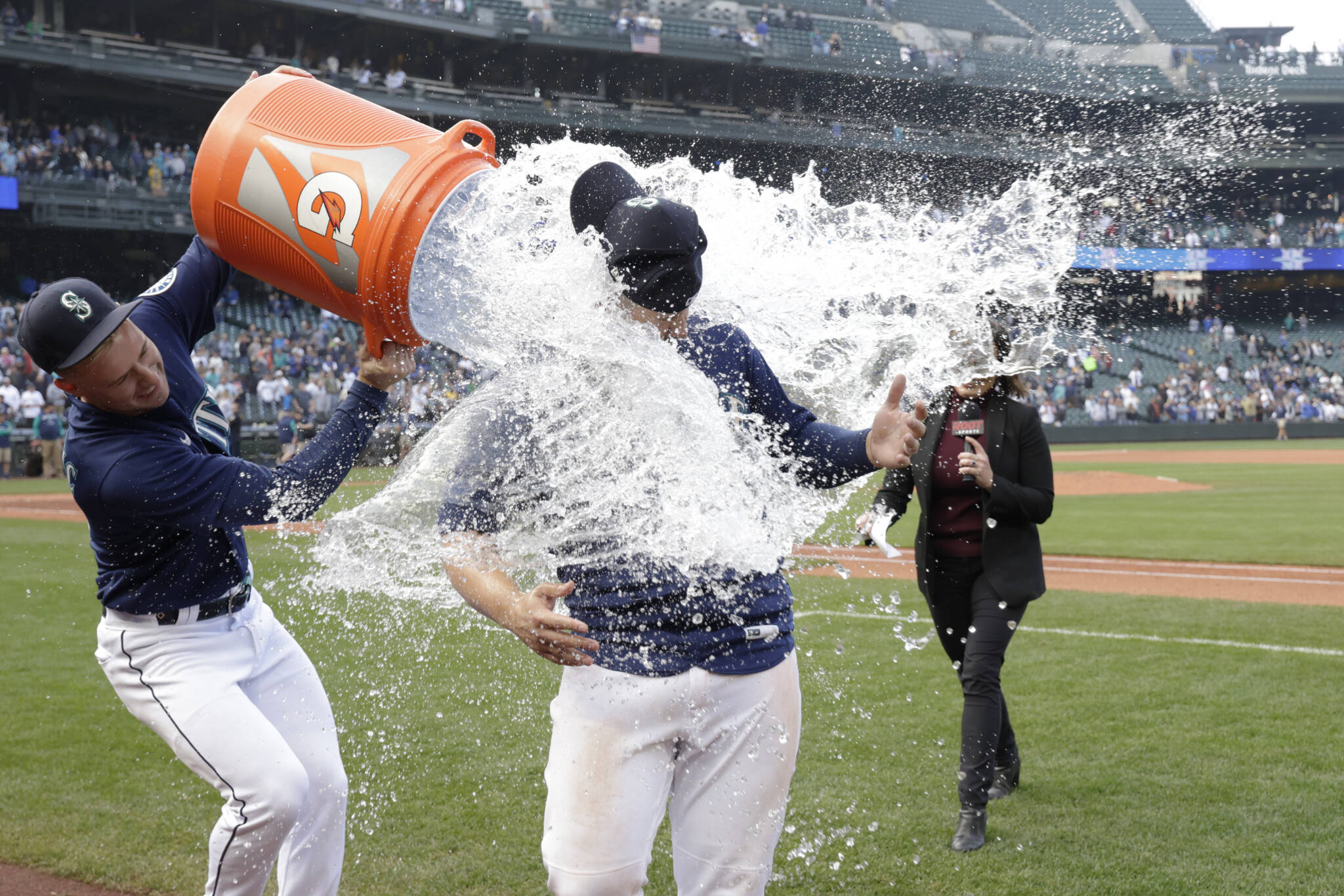 Mariners’ Ty France is doused by water by Jarred Kelenic after the team’s 5-4 walk-off win over the Tigers on Wednesday in Seattle. (AP Photo/John Froschauer)
