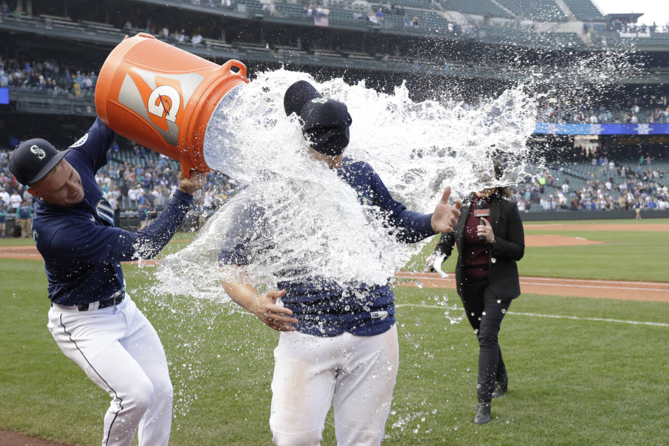 Seattle Mariners' Ty France is doused Jarred Kelenic after the team's 5-4 win over the Detroit Tigers in a baseball game Wednesday, Oct. 5, 2022, in Seattle. (AP Photo/John Froschauer)