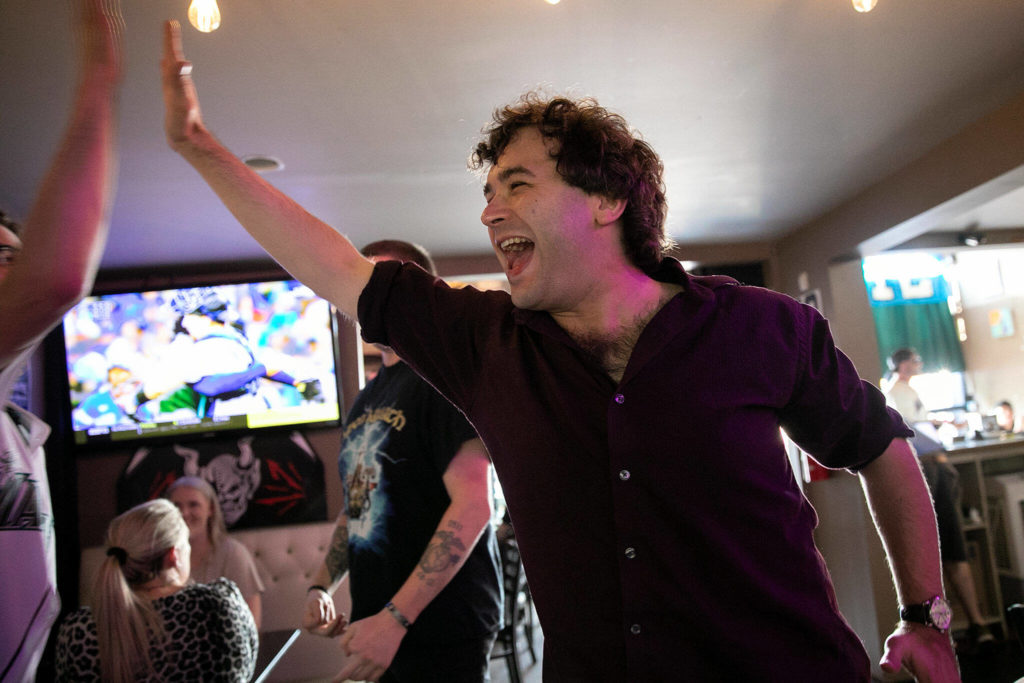Matthew Kenyon, 33, doles out some high fives after the Mariners’ Wildcard Game 1 win over the Toronto Blue Jays on Friday, at Brews Almighty® in Everett. (Ryan Berry / The Herald)
