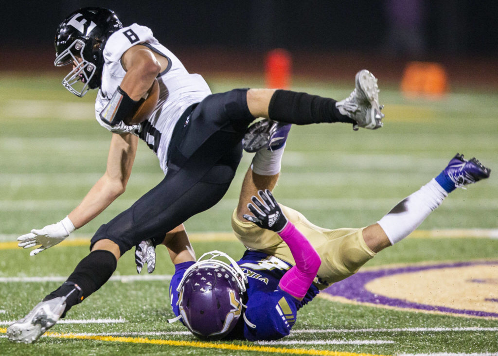 Eastlake’s Grady Woodward falls after being tackled by Lake Stevens’ Gabe Kylany during the game on Friday, Oct. 7, 2022 in Lake Stevens, Washington. (Olivia Vanni / The Herald)
